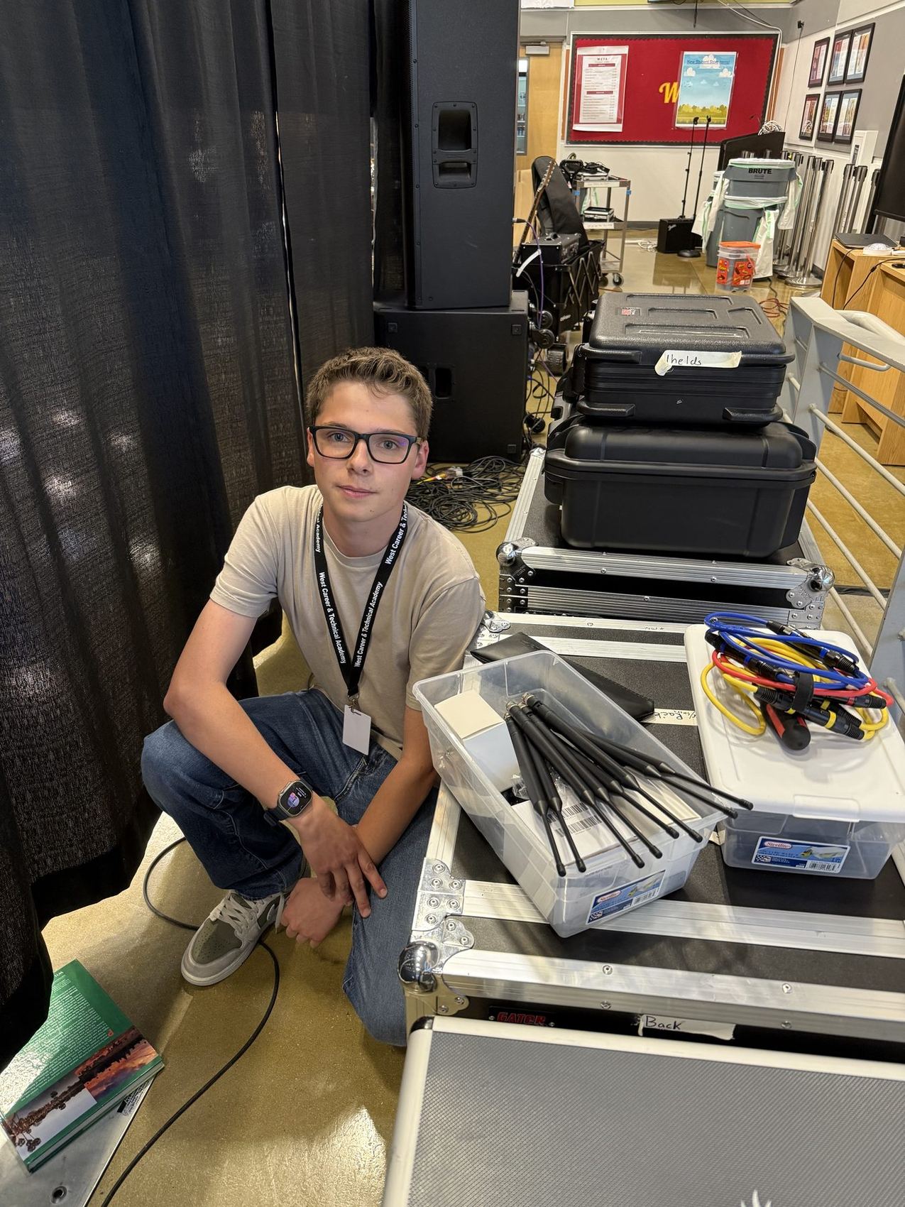 An AV Club member setting up microphone stands and speaker cases before Culture Fest